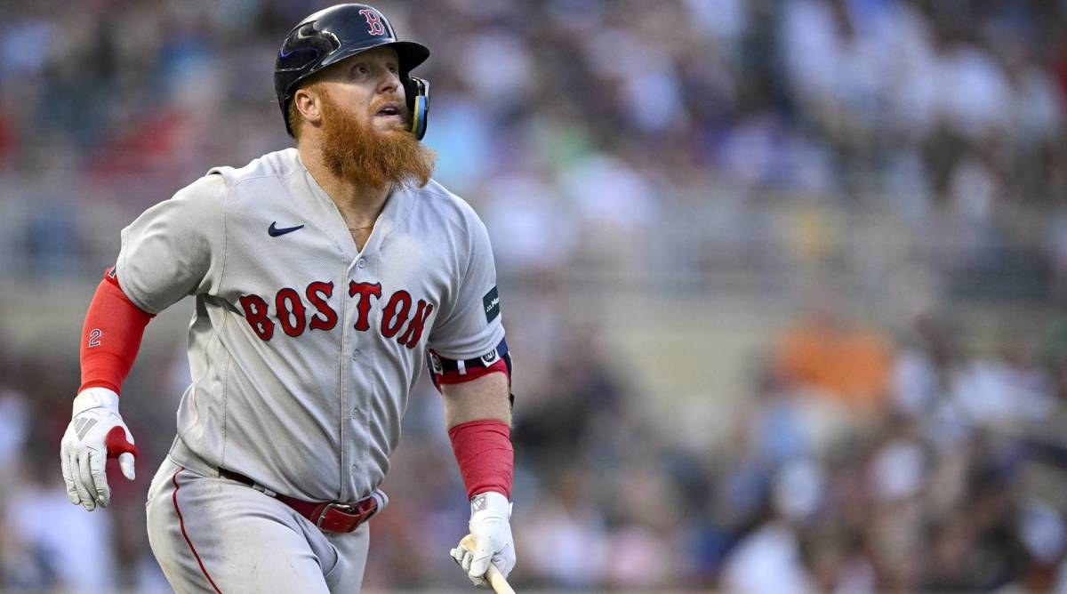 Red Sox designated hitter Justin Turner looks up after hitting a ball in the air during a game.